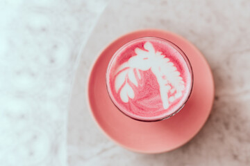 Two trendy beetroot lattes with latte art and flower petals on the foam.