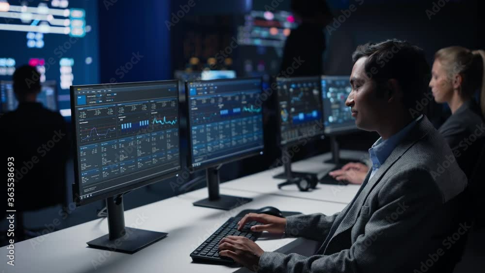 Aufkleber confident male data scientist works on personal computer in big infrastructure control room. stock m