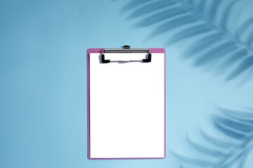 blank empty clipboard with palm shadows on blue background. mockup