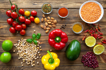 Selection of healthy food on wooden background, top view. Fresh vegetables, fruits and cereals.