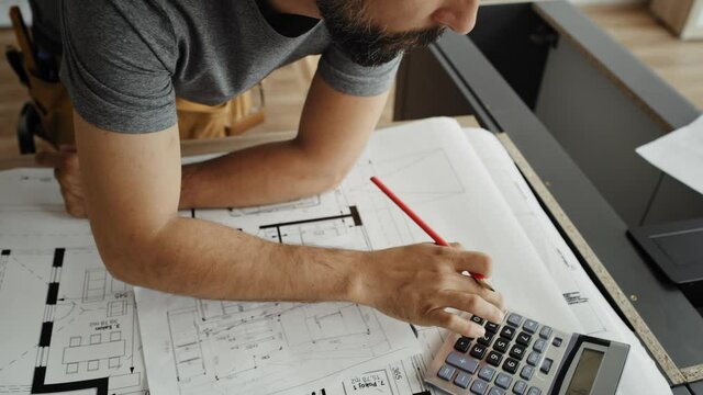 Front view video of carpenter writing and calculating. Shot with RED helium camera in 8K