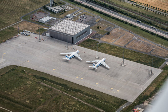 Leipzig Schkeuditz, Germany, July 2020 Maintenance Apron In Front Of Air Traffic Control Tower With Cargo Airplanes Antonov AN-124 Parked In Front Of Hanger  - Aerial View