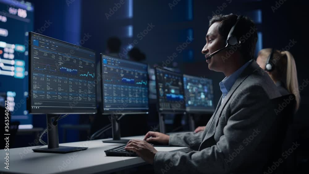 Poster professional customer support specialist wearing headset talks with client and works on computer in 