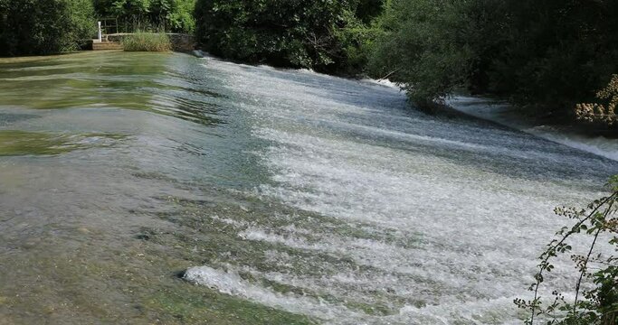 El agua del rio cae por el azud