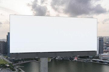 Blank white road billboard with Singapore cityscape background at sunset. Street advertising poster, mock up, 3D rendering. Front view. The concept of marketing communication to sell idea. © VideoFlow