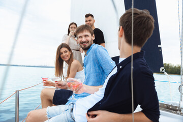 Group of happy friends drinking vodka cocktails at boat party outdoor, cheerful and happy. Young...