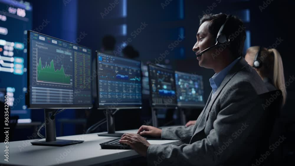Poster confident male trader talking into headset works on computer with screen showing finance statistics,