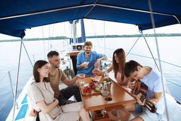 Group of happy friends drinking vodka cocktails at boat party outdoor, cheerful and happy. Young...