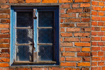 Old blue window in red brick wall