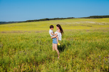 Portrait of a beautiful mom and son on a walk on nature field road