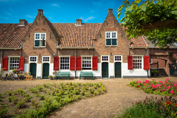 Fototapeta na wymiar Medieval Dutch almshouses on a sunny summer day with a blue sky