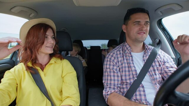 family trip, cheerful happy couple husband with wife and male sons enjoying joint trip by car during summer holidays after quarantine cancellation