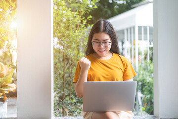 Happy successful business of asian freelance people business female expressed confidence embolden working with laptop computer sitting on a bench in coffee shop like the background,communication