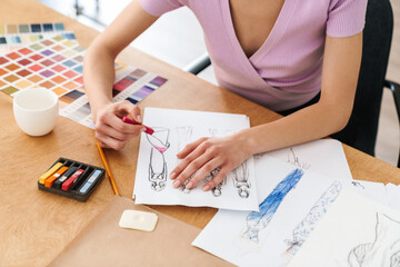 Cropped photo of caucasian woman fashion designer making sketches