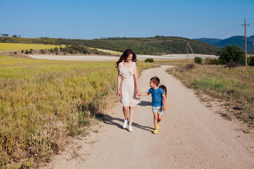 Beautiful woman goes with her son on a road