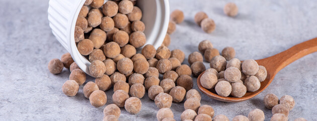 Dry raw brown tapioca pearls isolated on gray cement concrete background, close up, ingredient of making bubble boba tapioca milk tea.