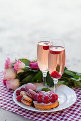 Beautiful and romantic proposal on Saint Valentine's day in Paris - city of love. Bouquet of pink roses, two glasses of wine, macaroons, cake. Eiffel tower on background. Close up copy space. Tonned