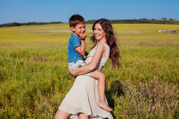 Fototapeta na wymiar Portrait of a beautiful mom and son on a walk on nature field road