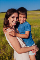 Portrait of a beautiful mom and son on a walk on nature field road