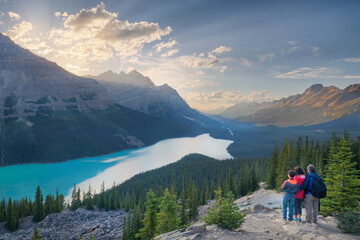 a family of hikers observing sunset over Peyto lake in Canada