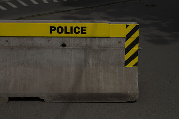 Police sign word on cordon - block  reinforcement made of concrete.