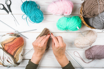 Knitting in woman hands. Close-up of hands knitting. Colorful threads. Selection of colorful yarn...