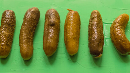 Six pickles placed on a green background