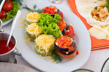 appetizer from fried eggplant and zucchini with cheese and tomatoes.