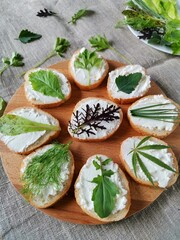 laying on a burlap of fresh greens and sandwiches with soft cheese