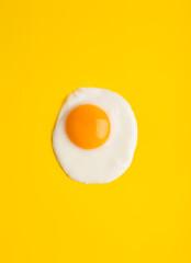Close up fried egg at yellow background with free space