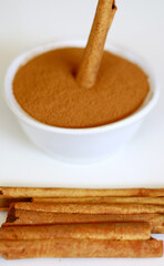 Cinnamon and cinnamon powder on white background.