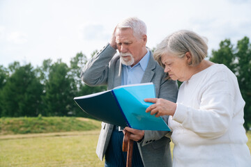 Thoughtful Portrait of a gray haired senior Caucasian people holding a folder with documents