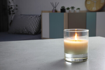 The luxury lighting aromatic scent clear color glass candle is displayed on the grey table in the minimal design bedroom