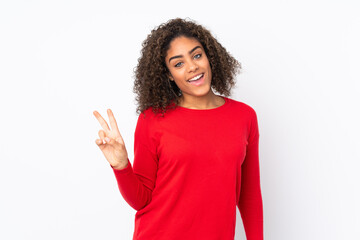 Young African American woman isolated on background smiling and showing victory sign