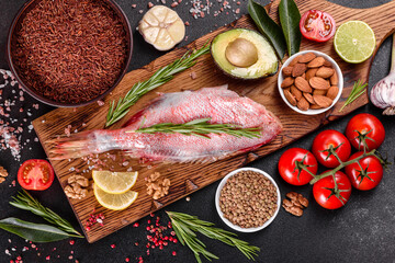 Raw fillet of red sea perch prepared for baking with spices and herbs