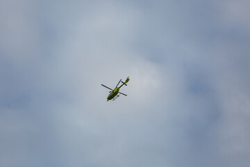 Helicopter flying in cloudy blue sky