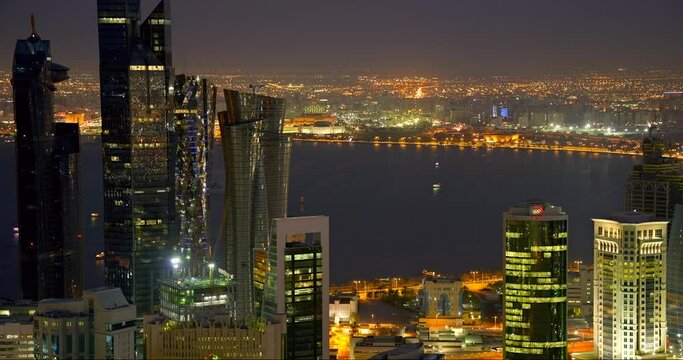 Iconic time-lapse of Doha's skyscraper business center. Boats and cars move as the city comes alive for the night life durning Ramadan.