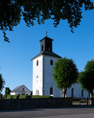 Fototapeta na wymiar Harlösa church is a white church that stands on a hill in the Scanian landscape in southern Sweden