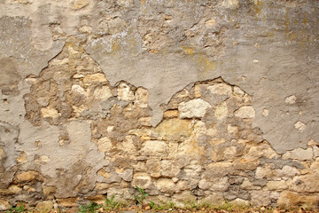 horizontal texture of an old wall made of rubble stone, brown sandstone, with the remains of cracked old plaster, a blank for the designer, wallpaper