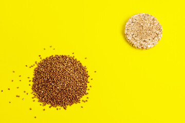 Buckwheat groats and cake on a yellow-white background.