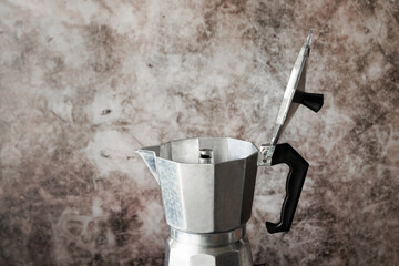 Moka pot italian style coffee maker with open lid on grunge texture wall. Coffee time in morning concept.
