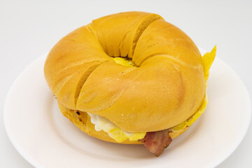 Egg Bagel with Bacon Eggs and Cheese on a White Plate