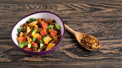 Top view of granola bowl and wooden spoon portion. Healthy hearty sweet and tasty food for breakfast. Color