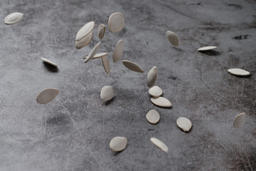 Fototapeta na wymiar Pumpkin seeds are dropped and bounced on the cement floor. Healthy eating and diet snack concept.