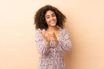 Obraz premium Young African American woman isolated on beige background applauding after presentation in a conference