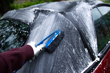 cleaning the tarpaulin roof of the convertible with foam cleaner.
