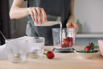Woman preparing healthy ice cream with strawberries and banana. Homemade dessert with no added...