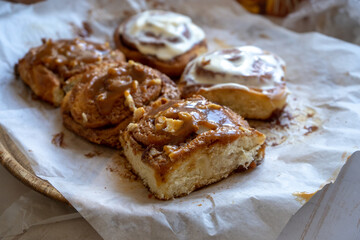 fresh baked homemade cinnamon rolls glazed with classic cream cheese and caramel, traditional cinnabons home baking