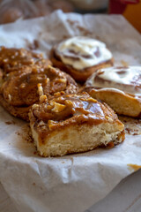 fresh baked homemade cinnamon rolls glazed with classic cream cheese and caramel, traditional cinnabons home baking