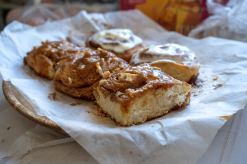fresh baked homemade cinnamon rolls glazed with classic cream cheese and caramel, traditional cinnabons home baking